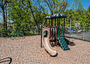 Thumbnail 20 of 25 - A playground with a brown slide and a green canopy.