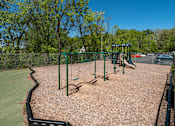 Thumbnail 21 of 25 - A playground with swings and a slide.