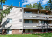 Thumbnail 15 of 18 - a white apartment building with a yard and grass
