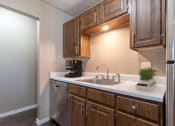 Thumbnail 8 of 29 - a kitchen with wooden cabinets and a stainless steel dishwasher