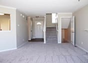 Thumbnail 5 of 16 - an empty living room with a white carpet and a staircase