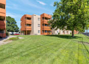 Thumbnail 15 of 18 - a grassy area with a tree in front of a building