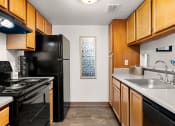 Thumbnail 9 of 18 - a kitchen with black appliances and wood cabinets