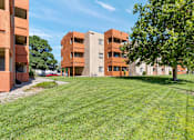 Thumbnail 25 of 25 - A large grassy area in front of apartment buildings.