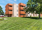 Thumbnail 23 of 25 - A large building with a green lawn in front.