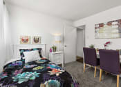 Thumbnail 5 of 12 - a bedroom with a bed and a desk with two chairs