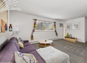 Thumbnail 2 of 12 - a living room with a purple couch and a table