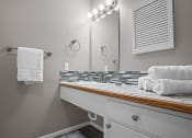 Thumbnail 12 of 29 - a bathroom with a sink and a mirror and towels