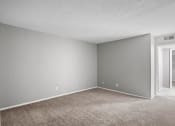 Thumbnail 10 of 29 - an empty room with a carpeted floor and a door