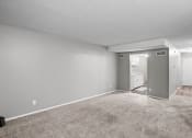 Thumbnail 6 of 29 - an empty living room with carpeting and a white bathroom
