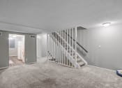 Thumbnail 9 of 29 - a white carpeted living room with a staircase