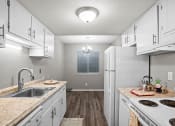 Thumbnail 1 of 29 - a kitchen with white cabinets and a sink and a refrigerator