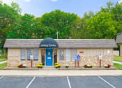 Thumbnail 25 of 29 - the leasing center is located on the corner of a parking lot