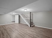 Thumbnail 5 of 29 - an empty living room with a white staircase and wood flooring