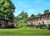 Thumbnail 11 of 12 - green lawn in front of a brick apartment building