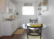 Thumbnail 2 of 12 - a small kitchen with a table and chairs and a sink