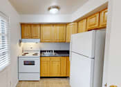 Thumbnail 5 of 16 - A kitchen with wooden cabinets and a white refrigerator.