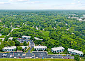 Thumbnail 24 of 25 - aerial view of an apartment complex with parking lot and trees