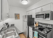Thumbnail 3 of 25 - modern apartment kitchen with stainless steel appliances and sink