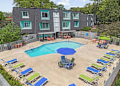 Thumbnail 21 of 25 - an aerial view of a swimming pool and patio with chairs and an umbrella
