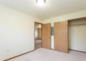 Thumbnail 5 of 32 - a bedroom with two doors and a carpeted floor