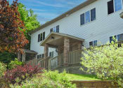 Thumbnail 26 of 32 - a large white house with a wooden porch and stone pillars