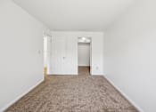 Thumbnail 14 of 34 - A room with a carpeted floor and a white door.