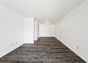 Thumbnail 18 of 34 - A long hallway with a carpeted floor and white walls.