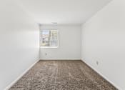 Thumbnail 15 of 34 - A room with a carpeted floor and a window.