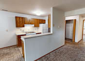 Thumbnail 8 of 35 - A kitchen with white walls and wooden cabinets.