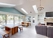 Thumbnail 13 of 35 - A modern living room with a fireplace and a large wooden table.
