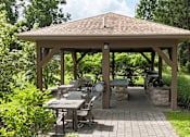 Thumbnail 19 of 35 - A wooden gazebo with a table and chairs is surrounded by greenery.
