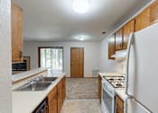 Thumbnail 10 of 35 - A kitchen with white appliances and wooden cabinets.