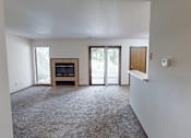 Thumbnail 7 of 35 - A living room with a fireplace and sliding glass doors.