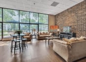 Thumbnail 19 of 26 - a living room with couches and a table in front of a wall of windows