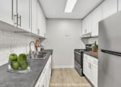 Thumbnail 1 of 26 - a white kitchen with stainless steel appliances and white cabinets