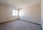 Thumbnail 6 of 20 - A room with a window and carpeted floor.
