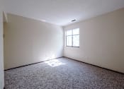 Thumbnail 7 of 20 - A room with a window and carpeted floor.