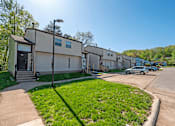 Thumbnail 17 of 20 - A sunny day at a residential area with houses and parked cars.
