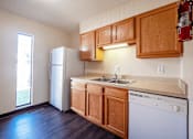 Thumbnail 1 of 20 - A kitchen with wooden cabinets and a white dishwasher.