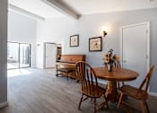 Thumbnail 9 of 20 - A dining room with a table and chairs.