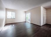 Thumbnail 3 of 20 - A room with wooden floors and two windows.