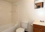 Thumbnail 3 of 15 - A white toilet sits next to a white sink in a bathroom.