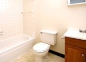Thumbnail 11 of 15 - A white toilet sits next to a bathtub in a bathroom.