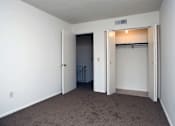 Thumbnail 2 of 15 - A room with a carpeted floor and a closet with a light on.