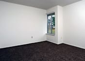 Thumbnail 5 of 15 - A room with a window and carpeted floor.