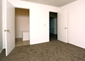 Thumbnail 4 of 15 - A room with a carpeted floor and two doors.