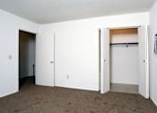 Thumbnail 15 of 15 - A room with white walls and carpeted floor with a white door and a white closet with a white door.