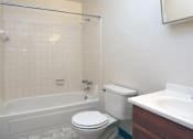 Thumbnail 12 of 15 - A white toilet sits next to a bathtub in a bathroom.
