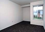 Thumbnail 10 of 15 - A room with a window and a carpeted floor.